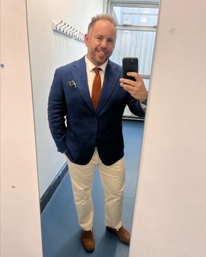 Navy Blazer with Orange Textured Tie and Cream Trousers